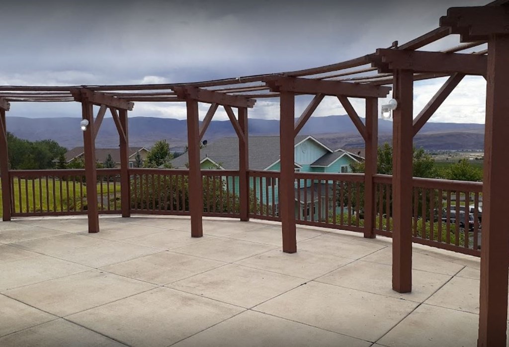 a balcony with a view of a house and a cloudy sky