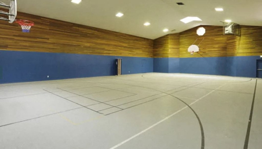 a basketball court in a gym with a basketball hoop