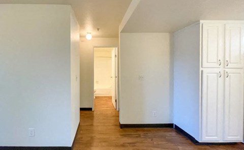 an empty living room with white walls and a wooden floor