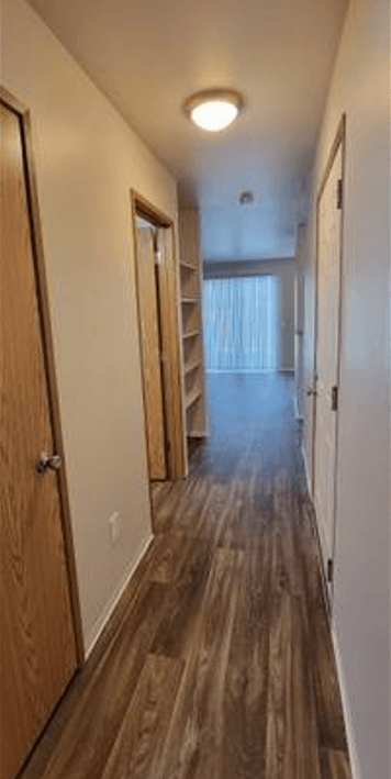 a hallway with a wood floor and a staircase