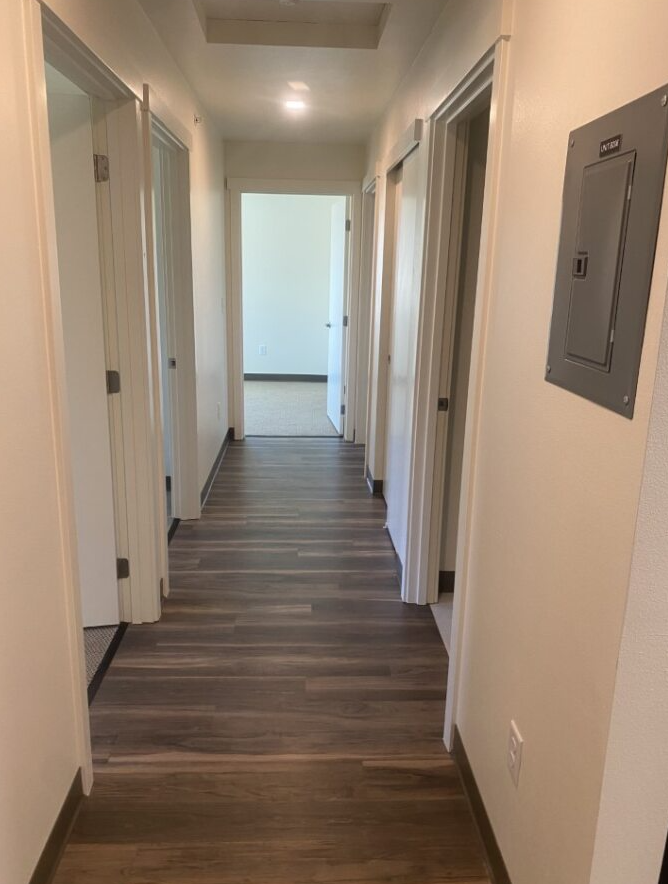 a hallway with wooden floors and white walls and doors