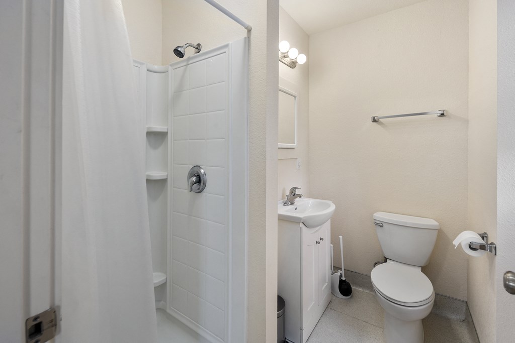 a bathroom with a toilet and a sink and a shower