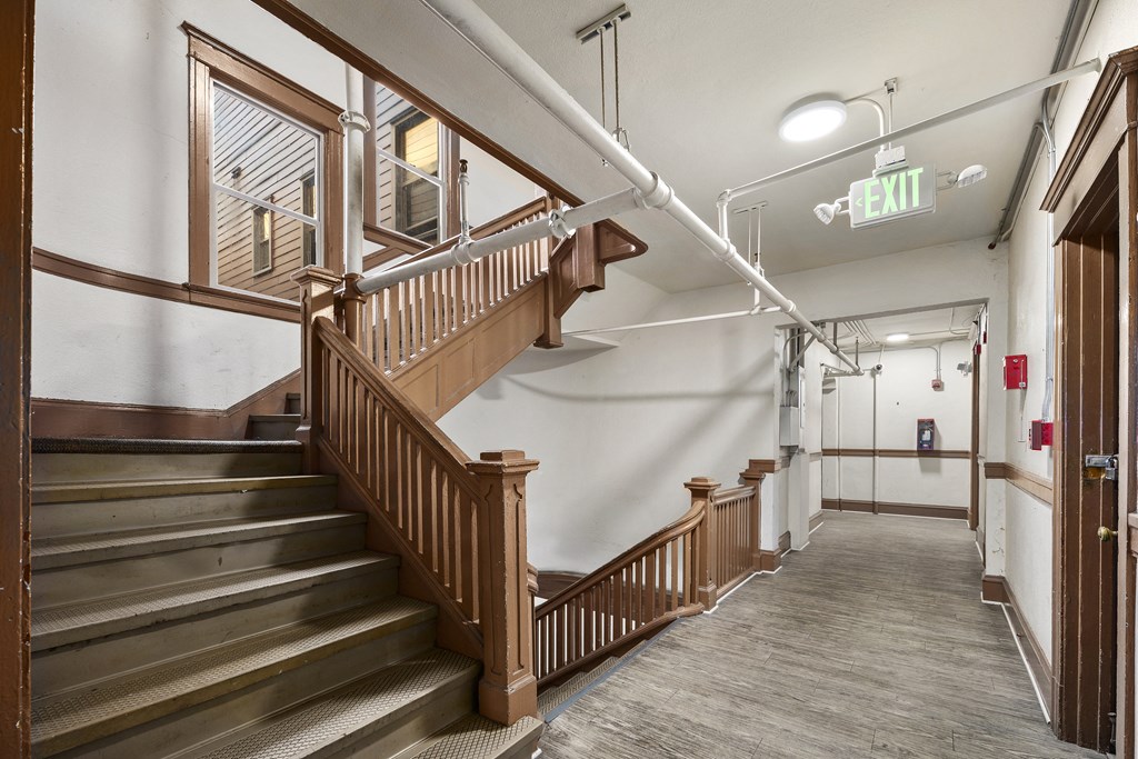 the lobby of a building with stairs and a wooden staircase