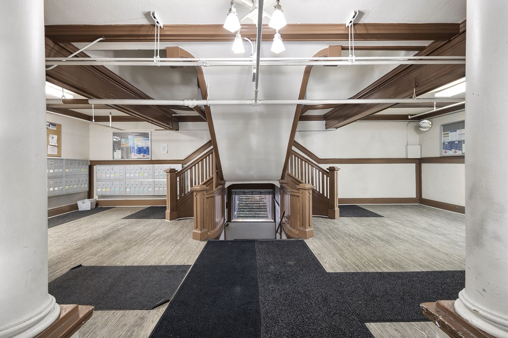 the lobby of a building with stairs and rugs