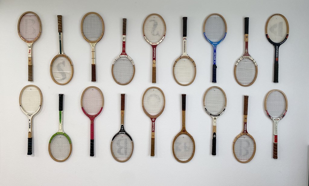 A collection of tennis rackets of different colors and brands.