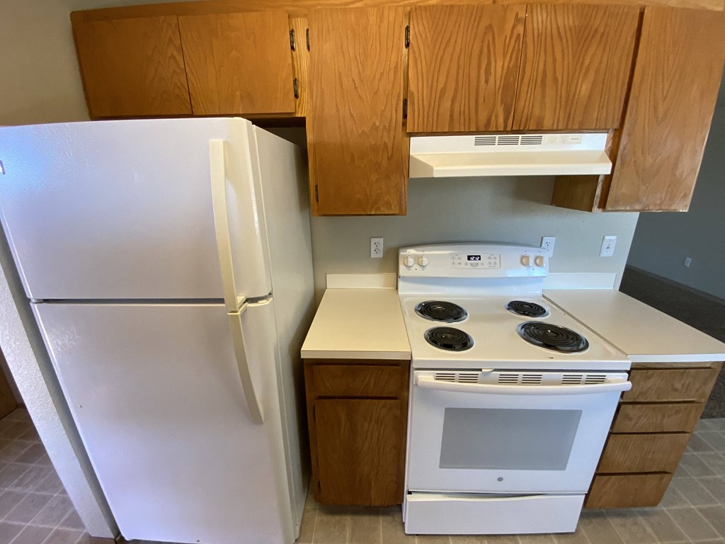 a kitchen with white appliances and a refrigerator