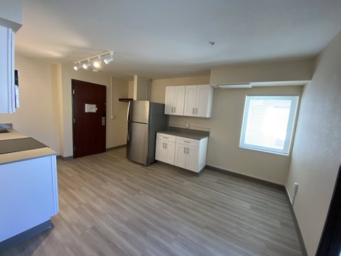 A kitchen with white cabinets and a wooden floor.