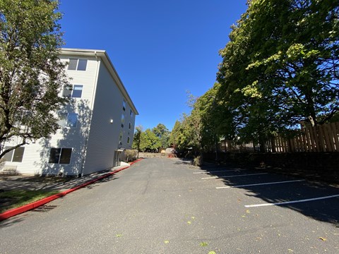 A long, quiet street with apartment buildings on either side.