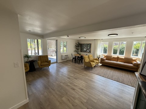 A living room with a yellow sofa and a wooden floor.