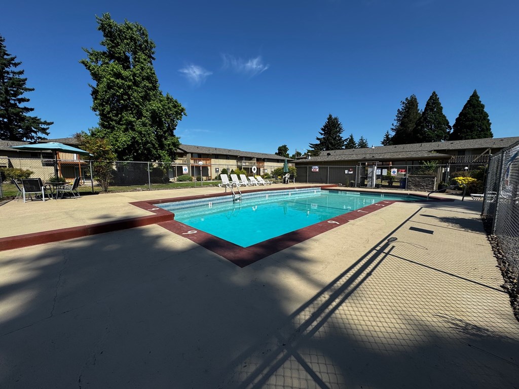 A large outdoor swimming pool surrounded by a fence.