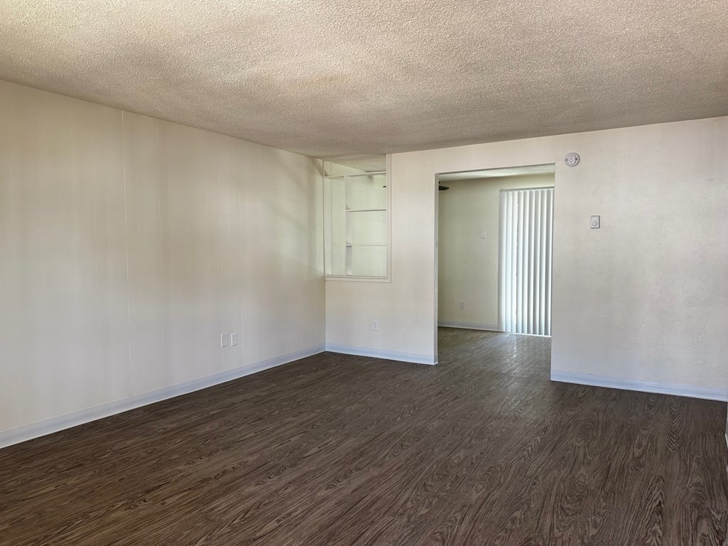 A room with wooden flooring and a white door.