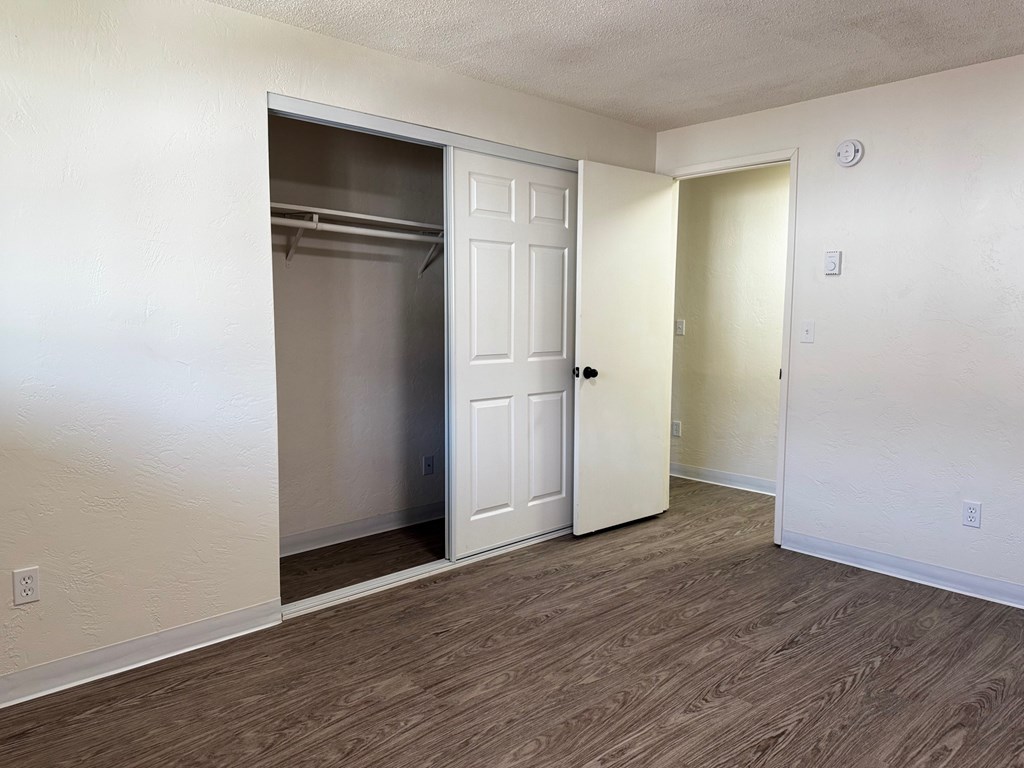 A room with a white door and a closet with a white door.