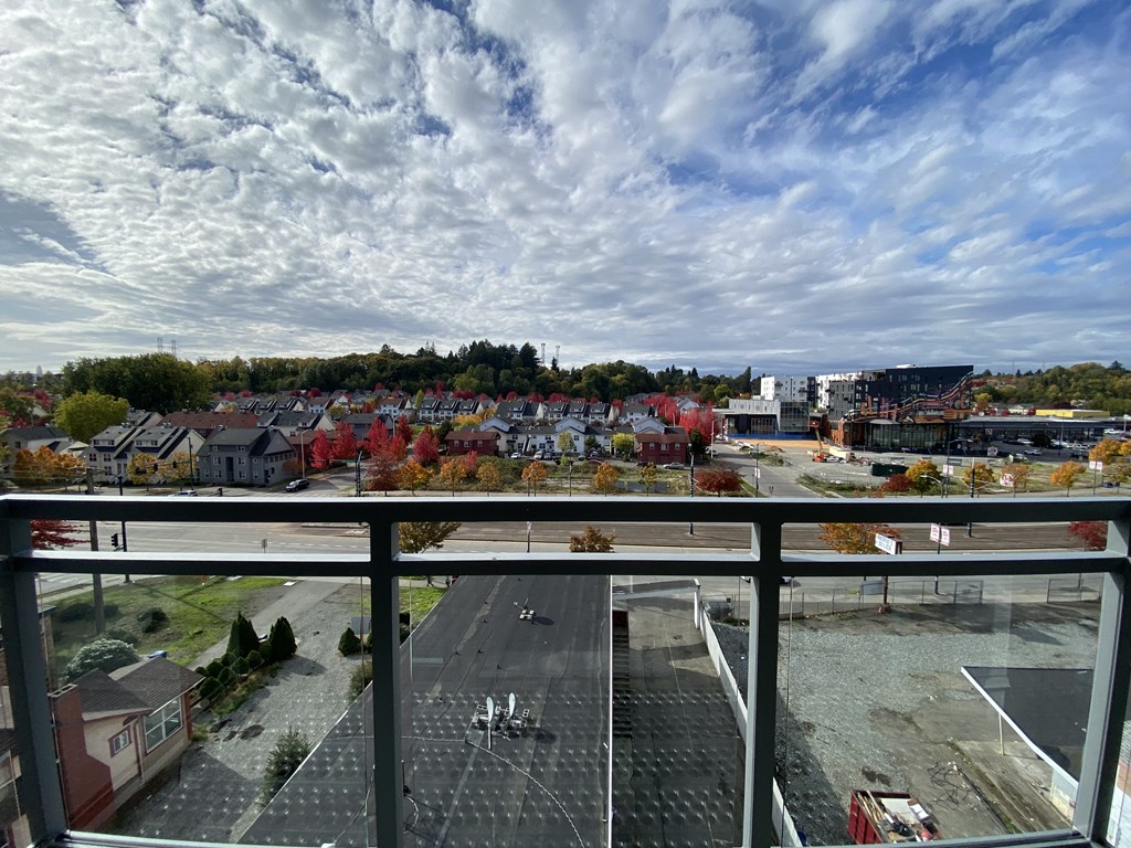 a balcony with a view of a city under a cloudy sky