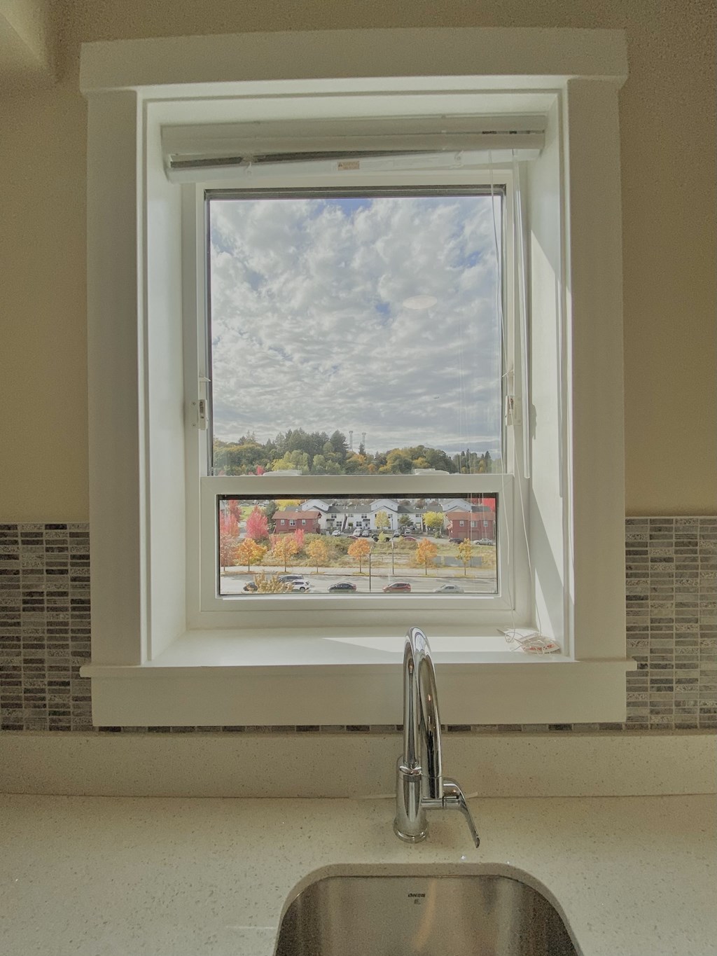 a window over a kitchen sink with a view of a field