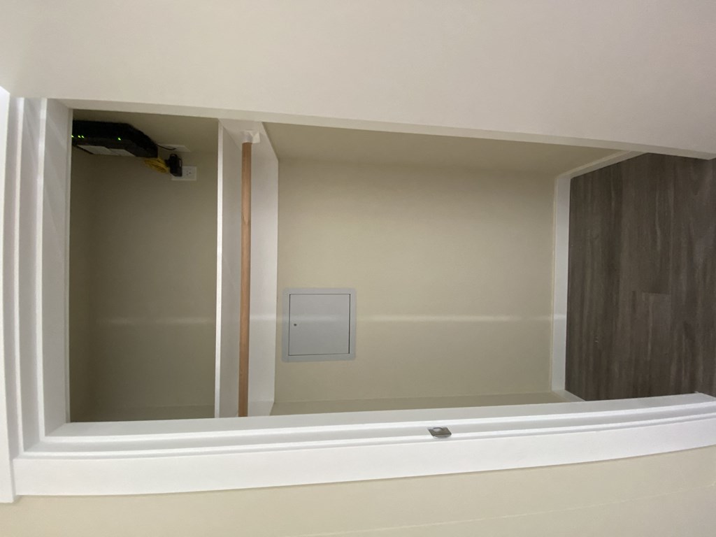 a large white window with a white wall and a white handle on the wall