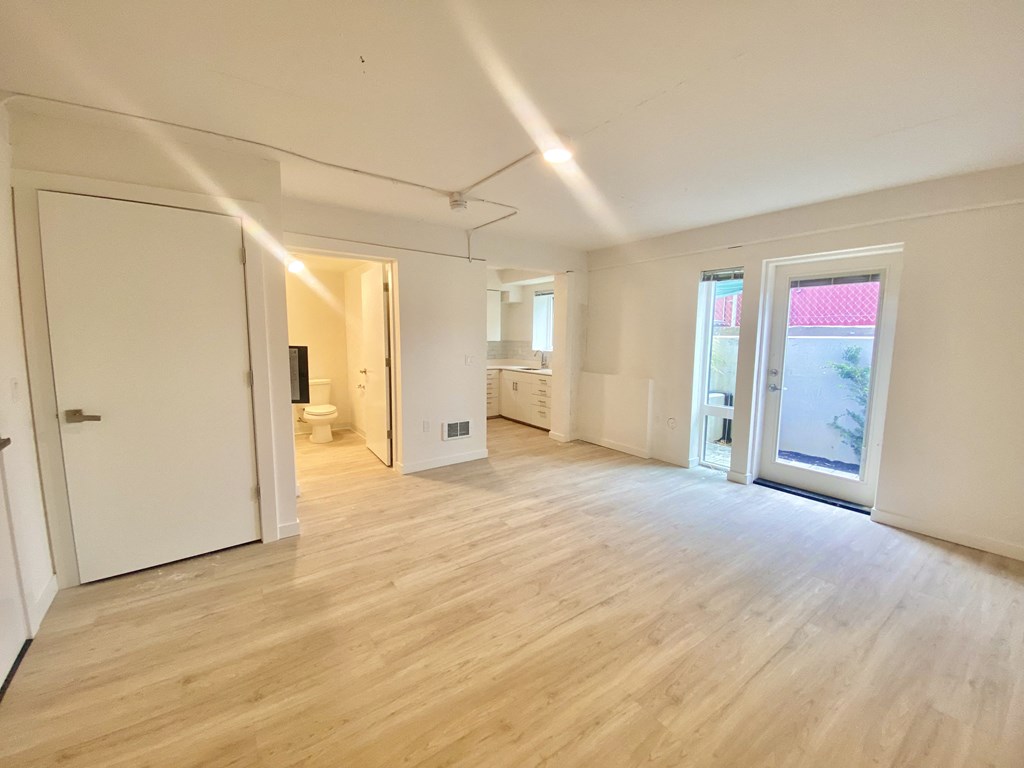 an empty living room with white walls and a sliding glass door