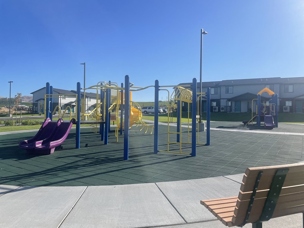 a playground with a bunch of slides and a bench