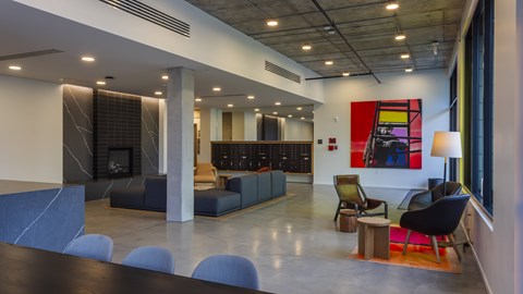 A modern office space with a fireplace and a large painting on the wall.