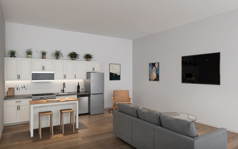 A modern kitchen with a grey sofa and wooden flooring.