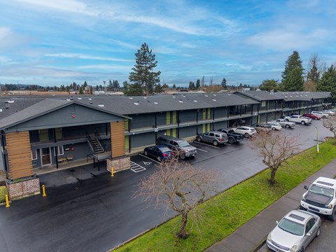 A parking lot with cars and a building in the background.