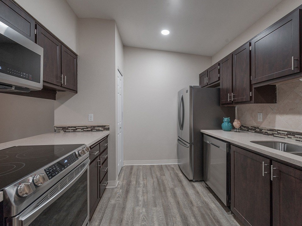 a kitchen with stainless steel appliances and wooden cabinets