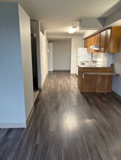 A kitchen with wooden cabinets and a white refrigerator.