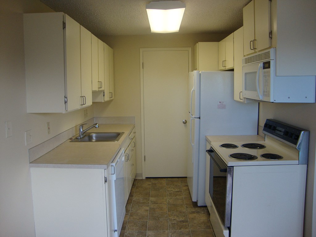 A kitchen with white appliances and cabinets.