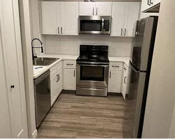 a kitchen with stainless steel appliances and white cabinets
