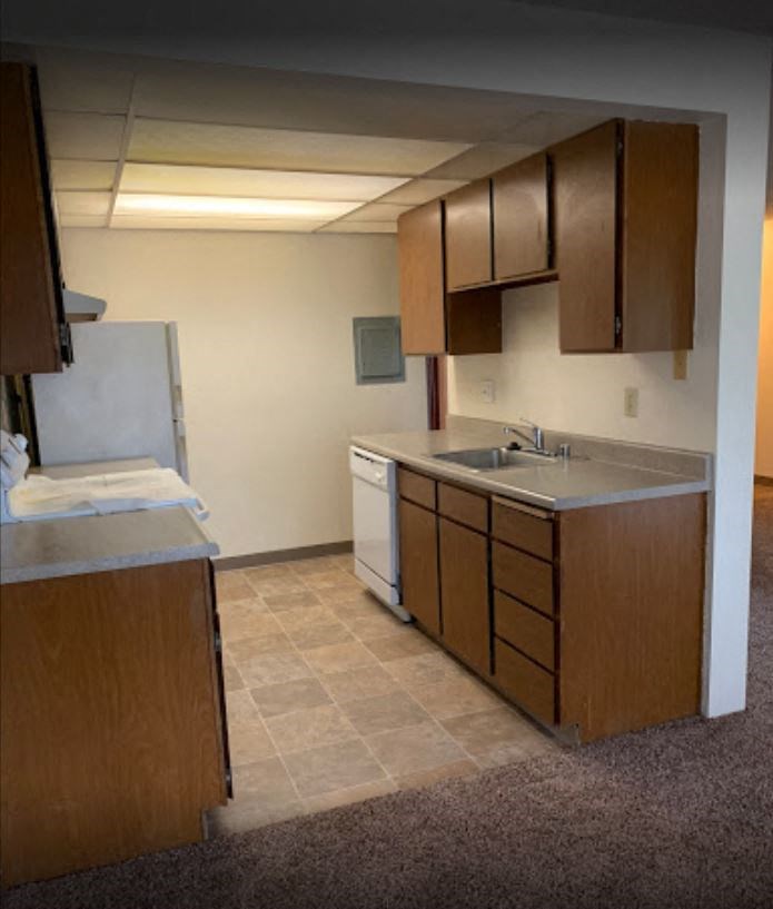 an empty kitchen with wooden cabinets and a sink
