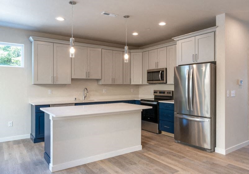 a kitchen with white cabinets and a stainless steel refrigerator