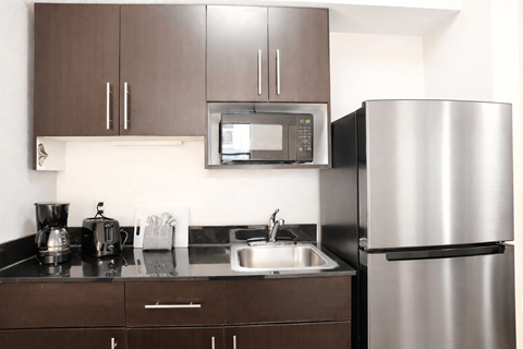 A modern kitchen with a stainless steel refrigerator and a microwave above the stove.