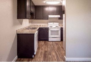 a kitchen with wooden floors and white appliances