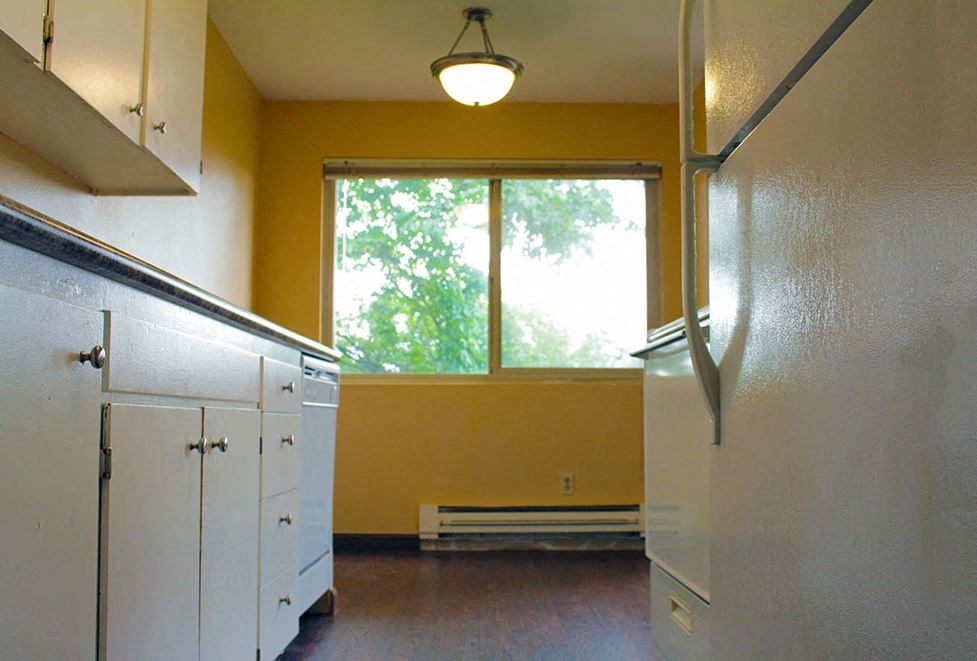 a kitchen with a large window and white cabinets