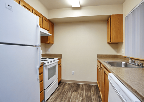 A kitchen with a white refrigerator, white oven, and white dishwasher.