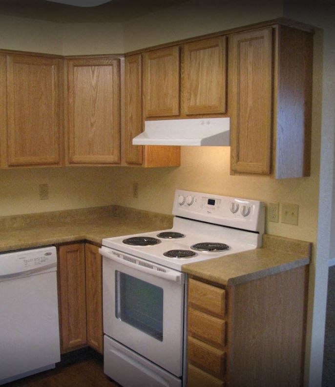 a kitchen with white appliances and wooden cabinets