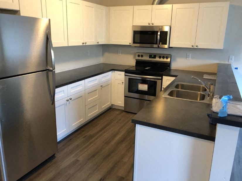 a kitchen with stainless steel appliances and white cabinets