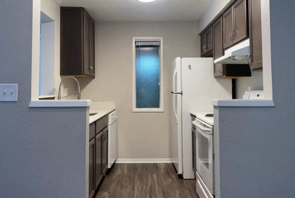a kitchen with white appliances and a refrigerator