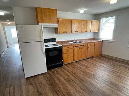 a kitchen with a stove refrigerator and a sink