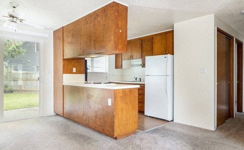 a kitchen with wooden cabinets and a white refrigerator