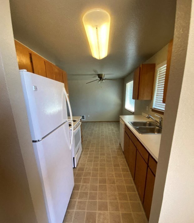 a kitchen with a white refrigerator and a sink