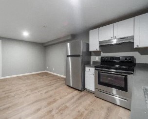 a kitchen with stainless steel appliances and a wooden floor