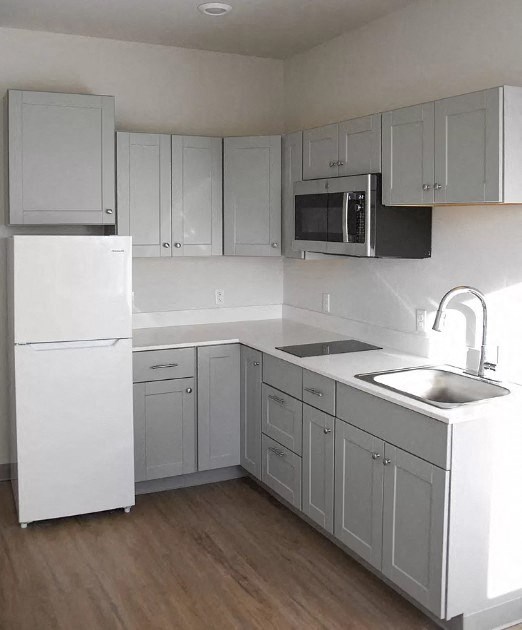 a white kitchen with a sink and a refrigerator