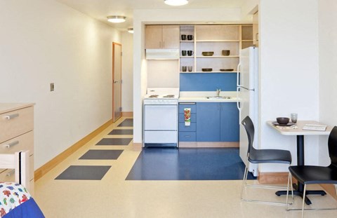 A kitchen with a table and chairs.