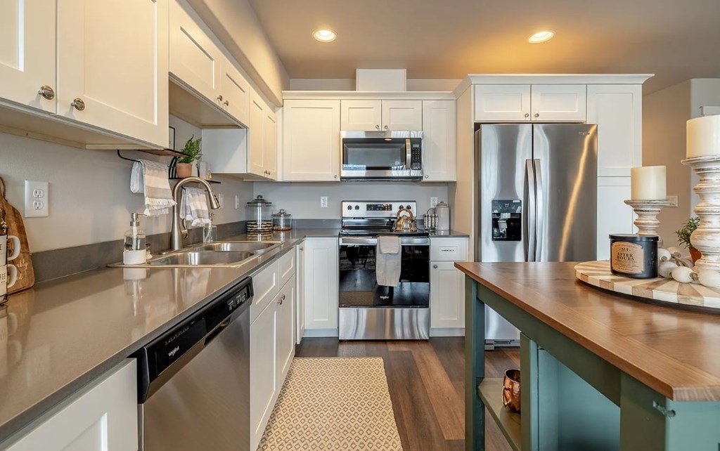 A kitchen with a stainless steel refrigerator and a wooden counter.