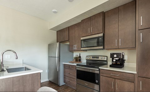 A kitchen with brown cabinets and stainless steel appliances.