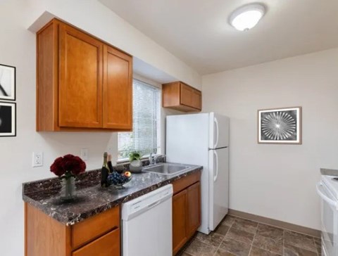 A kitchen with brown cabinets and a white refrigerator.