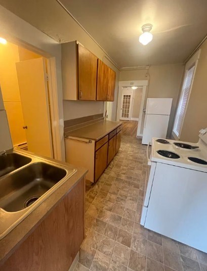 A kitchen with a white refrigerator and a stove top oven.