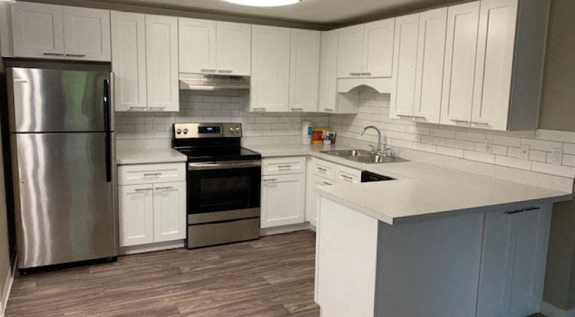 a kitchen with white cabinets and stainless steel appliances