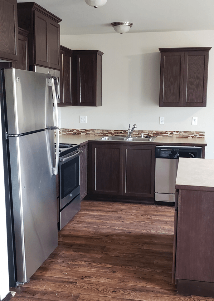 a kitchen with dark wood cabinets and stainless steel appliances