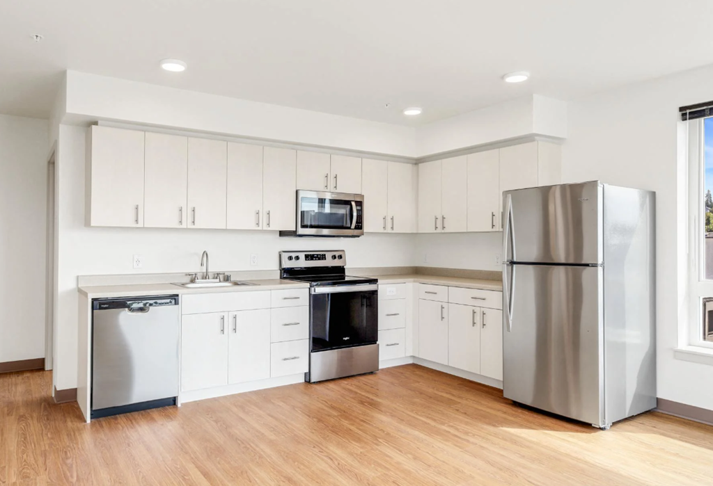 a kitchen with white cabinets and stainless steel appliances